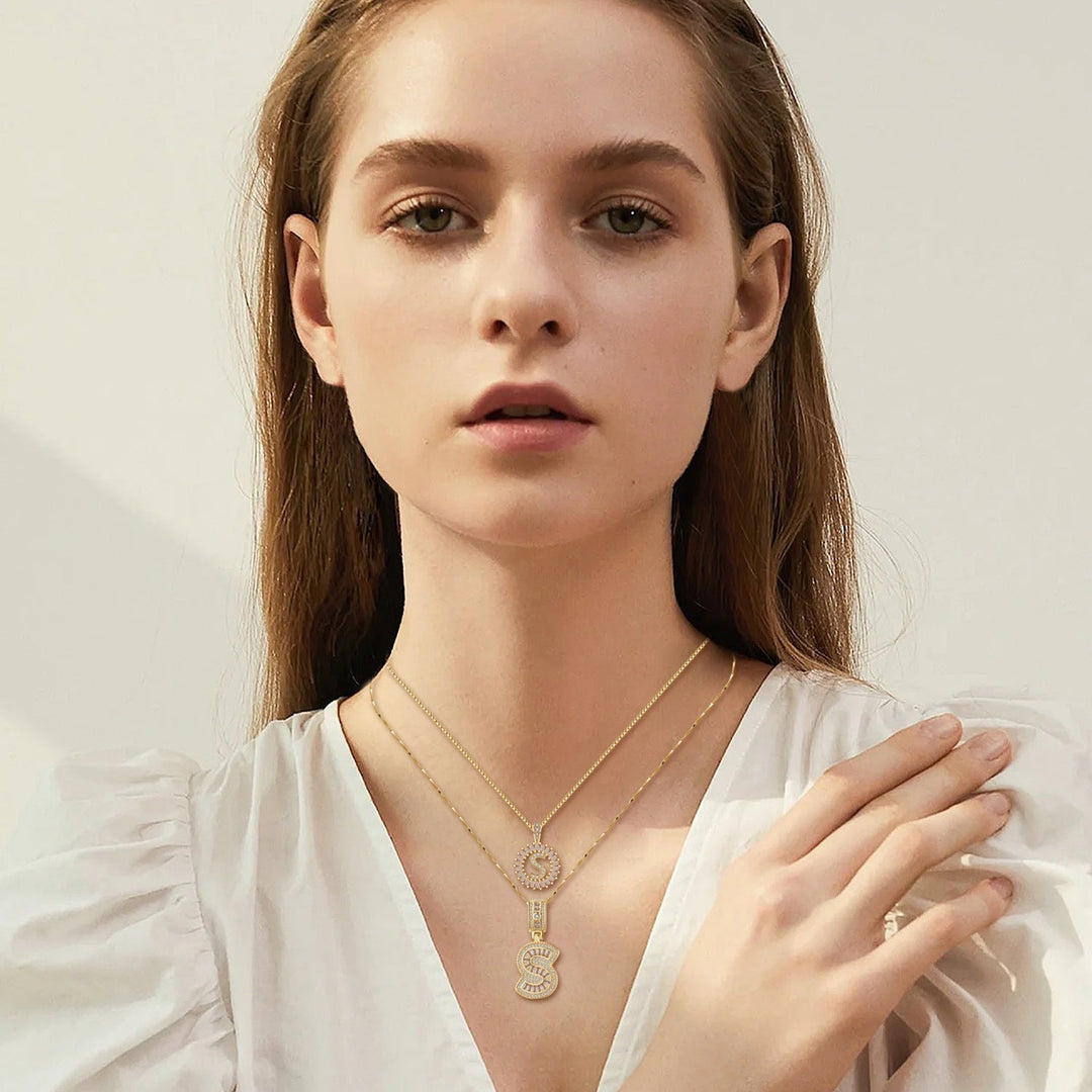 Ulla – elegant set med initialshalsband i guld med pavéstenar