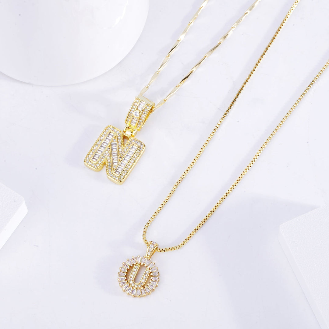 Ulla – elegant set med initialshalsband i guld med pavéstenar