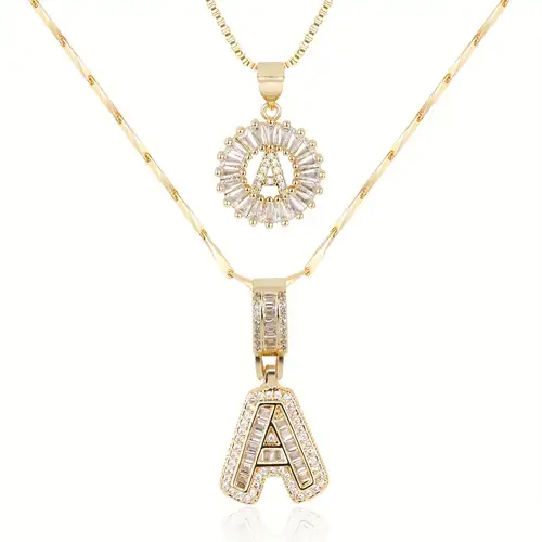 Ulla – elegant set med initialshalsband i guld med pavéstenar